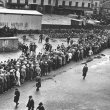Arbeitslosenschlange beim Stempeln im Hof des Arbeitsamtes Hannover, im Hintergrund: Wahlwerbung für Hitler